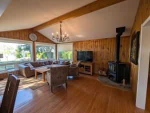 a living room with a couch and a table and a stove at Red Brickhouse Lakefront Cottage in Brechin