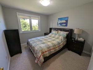 a bedroom with a bed and a window at Red Brickhouse Lakefront Cottage in Brechin