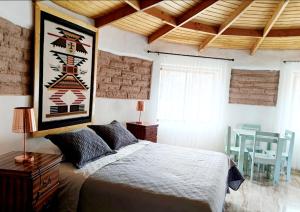 a bedroom with a large bed and a table at Desayuno Habitación TourLodge in San Pedro de Atacama +28 photos
