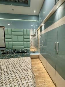 a bedroom with a large bed and glass walls at Ultra Luxurious 4 BHK VILLA in Bengaluru