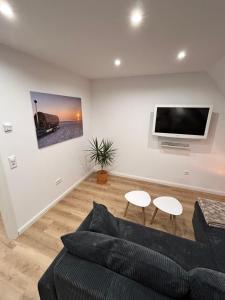 a living room with a couch and a flat screen tv at Ferienwohnung Südtondern in Uphusum