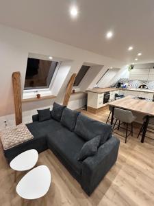 a living room with a black couch and a table at Ferienwohnung Südtondern in Uphusum
