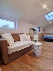 un soggiorno con un divano e un letto di La petite maison dans la prairie a Lamballe Armor