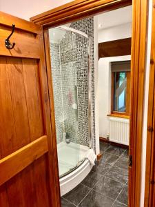 a bathroom with a shower with a glass door at The Swallows Rest, Avebury in Avebury