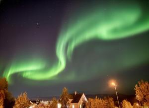 an image of the northern lights in the sky at Northern Lights Apt Midtgaard, Kvaløya Tromsø Modern 2BR, Free Parking in Tromsø +23 photos