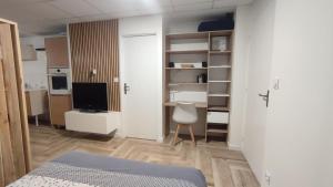 Una habitación con una cama y un televisor en una habitación. en Grand studio, avec terrasse, en Lauzerville