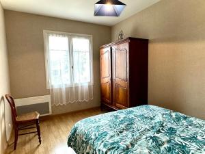 CassagneにあるGîte les Foysのベッドとドレッサーと窓のある寝室