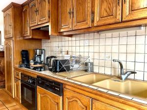 CassagneにあるGîte les Foysの木製のキャビネットとシンクを備えたキッチン