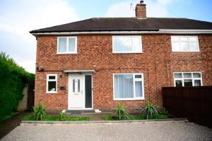 a red brick house with a white door at Modern house , Perfect for business trip & Families holiday or working proffesionals-5 min from M1 J25 , 500MB Wi-Fi , Netflix , Fully equiped kitchen , Asda supermarket 5 min walk , Free Secure parking with CCTV ,available monthly deals in Nottingham