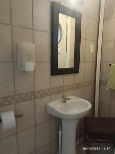 a bathroom with a sink and a mirror at alojamiento a pasos del casino dreams y zona gourmet in Punta Arenas