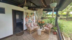 a patio with two chairs and a table on a porch at Boutique Hotel Her Waves & Wi-Fi in Tamarindo