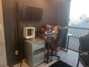 ペロタスにあるLoft central llのバルコニーにテレビとパソコンが置かれた机