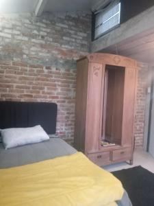 ペロタスにあるLoft central llのベッドと木製のキャビネットのある寝室 +1枚の写真