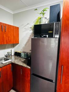 a kitchen with a stainless steel refrigerator with a microwave at Rest in the Village in Wilderness +6 photos
