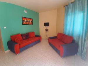 a living room with two couches and a tv at Le Noflaye in Sali Nianiaral