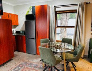 a kitchen with a table and chairs and a refrigerator at Rest in the Village in Wilderness