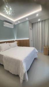 a bedroom with a large white bed and a window at Comfort Jardins II - Em frente ao Shopping- Neo Residence in Aracaju