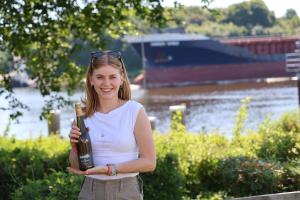a woman is holding a bottle of wine at Kanal 33 in Schafstedt +16 photos