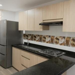 a kitchen with a stove and a refrigerator at Hermoso Apartamento para 6 personas en Yopal in Yopal +1 photo
