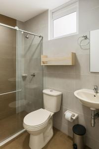 a bathroom with a toilet and a sink and a shower at Hermoso Apartamento para 6 personas en Yopal in Yopal