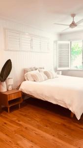 a bedroom with a large bed and a wooden floor at Tala & Sea in Forster
