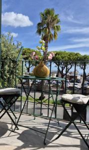 a table with a vase with a palm tree in it at Casa Gaeta in Gaeta