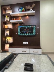 a living room with a tv on a wall at Shivalay - By Safarnama Stays in Varanasi
