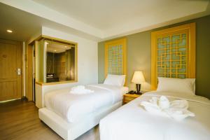 - 2 lits dans une chambre d'hôtel avec des draps blancs dans l'établissement Moon Dragon Hotel, à Chiang Mai