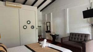 a room with a bed and a couch and a chair at Cabinas Bahía Uvita - Marino Ballena National Park Lodge in Uvita +45 photos