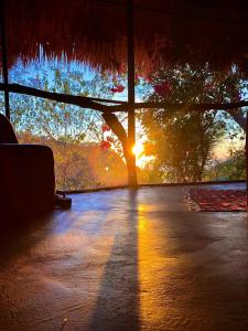a room with a view of a tree and the sunset at Flor de Arena in Arroyo Cruz
