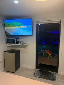 a large aquarium in a room with a flat screen tv at Den of Sin Guesthouse Wilton Manors FL in Fort Lauderdale