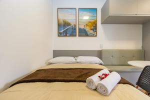 a bedroom with a bed with two towels on it at Studio Completíssimo Próximo a PUC PR - URB0403 in Curitiba