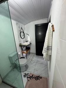 a bathroom with a shower and a toilet and a sink at Refúgio Vibe do Mar in Barra Velha +17 photos