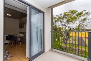 a sliding glass door leading to a balcony with a table at Studio Completíssimo Próximo a PUC PR - URB0403 in Curitiba