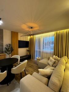 a living room with a couch and a table at Family & Business Apartments PREMIUM No1 - 1 Bedroom with Private Jacuzzi, Balcony, Parking in Warsaw