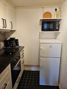 Una cocina con un refrigerador blanco y un microondas. en Home near both town and nature, en Norrköping
