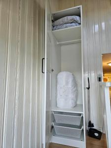 Un armario blanco con estantes y una almohada blanca. en Home near both town and nature, en Norrköping 3 fotos más