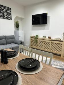 a dining room table with two black plates on it at Sky High Apartment in Streatham in London +3 photos