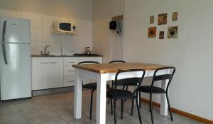 eine Küche mit Tisch und Stühlen und einem Kühlschrank in der Unterkunft Casas Tomillo Silvestre in Sierra de la Ventana + 6 Fotos