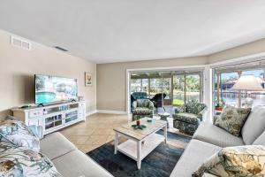Una sala de estar con un sofá y un televisor. en Sand Dollar Cottage - 910, en Siesta Key