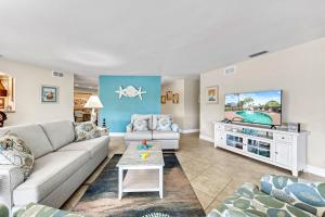 Una sala de estar con un sofá y un televisor. en Sand Dollar Cottage - 910, en Siesta Key