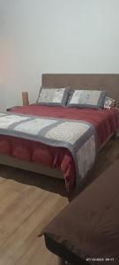 a bedroom with a large bed with red blanket and pillows at alojamiento a pasos del casino dreams y zona gourmet in Punta Arenas