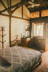Un dormitorio con una cama y una mesa en una habitación. en Hostal Rosa Mística, en Montañita