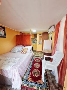 a small bedroom with a bed and a chair at EMME Escape in Saint Georgeʼs