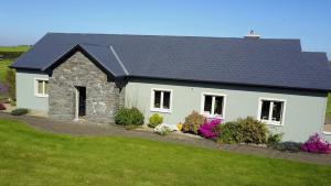 a white house with a black roof at Alder House Studio in Killarney