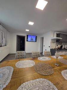a large room with a table and chairs and a flat screen tv at Casa Valy in Buşag
