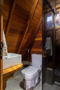 a bathroom with a white toilet and a sink at Chalé dos Campos in Vale do Capao +28 photos