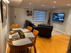 a living room with a table and chairs and a television at Place near the Coquitlam River Park in Coquitlam