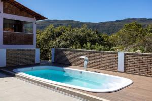 a swimming pool with a faucet on a house at Chalé dos Campos in Vale do Capao