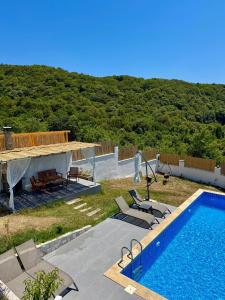 a view of a swimming pool and a house at Mugada Deluxe Bungalov in Güzelcehisar